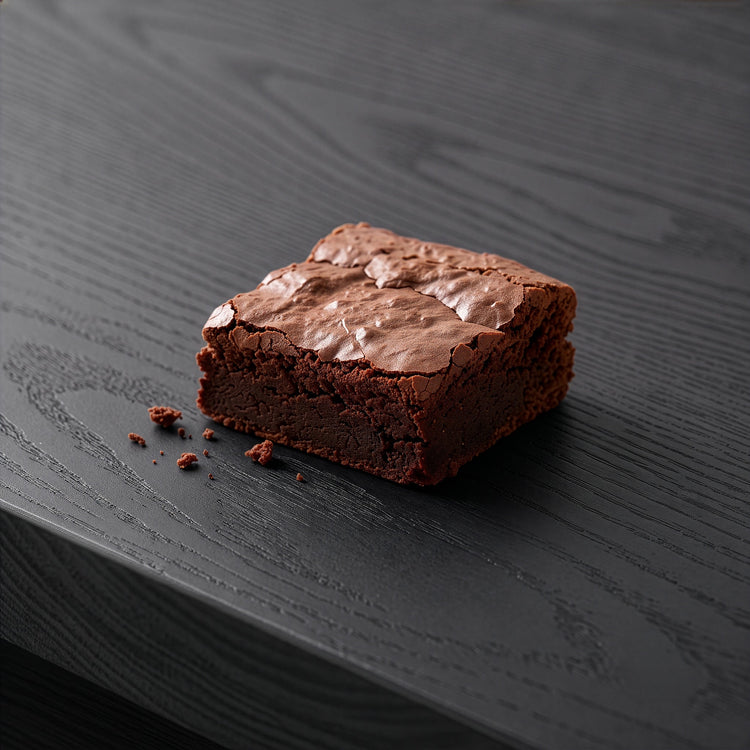 Chocolate Brownie on a dark charcoal table top.